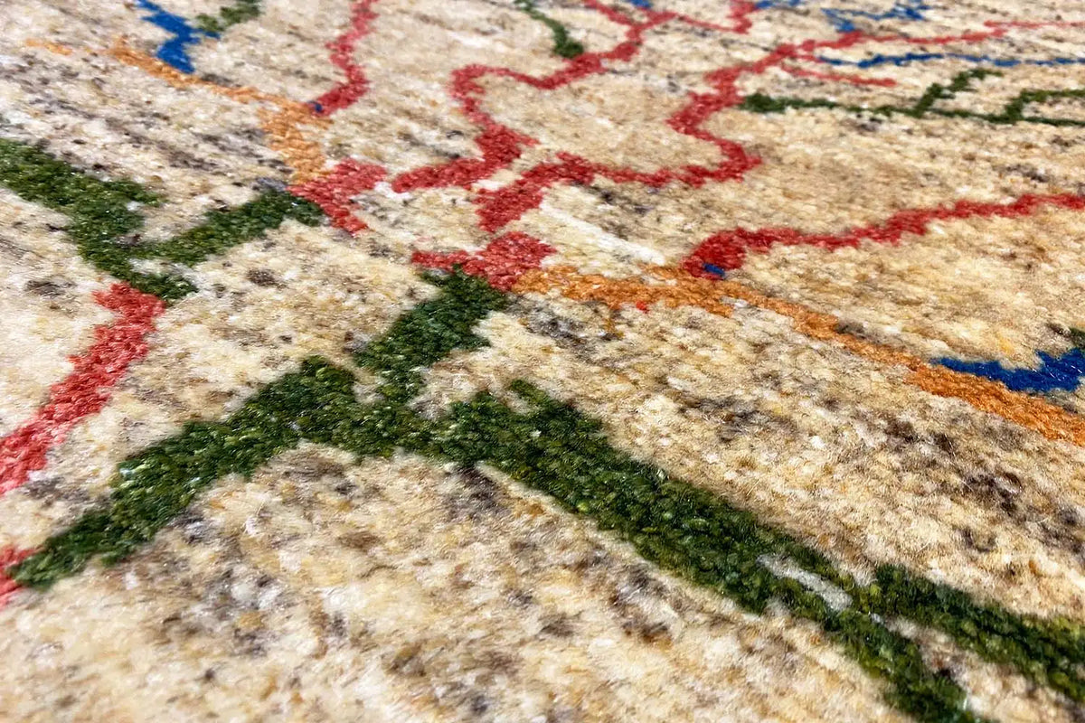 Rug with a beige pile and an abstract pattern in red, blue, and green