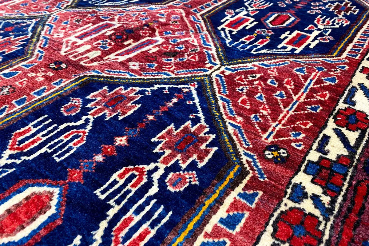 Oriental rug detail with red and blue diamonds, decorative lines, and ornaments