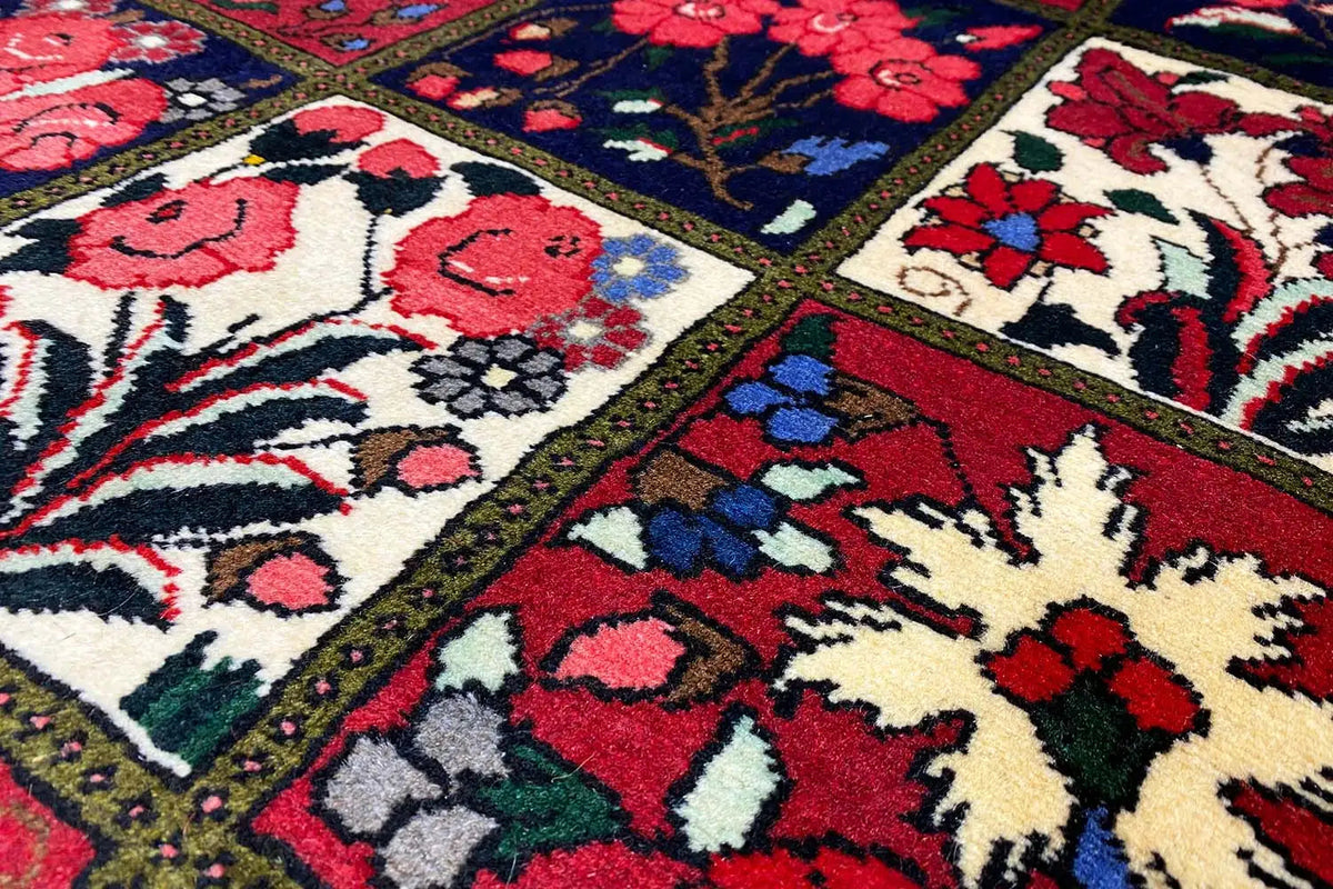 Oriental rug field with floral motifs and a border in red, blue, green, and cream