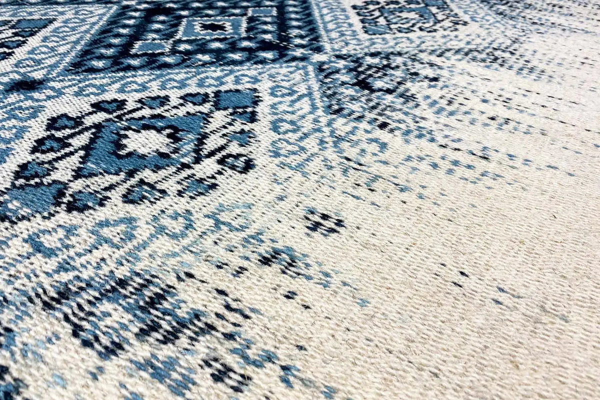 Kelim dhurrie rug with a blue ornamental pattern and brushed texture, close-up