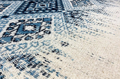 Kelim dhurrie rug with a blue ornamental pattern and brushed texture, close-up