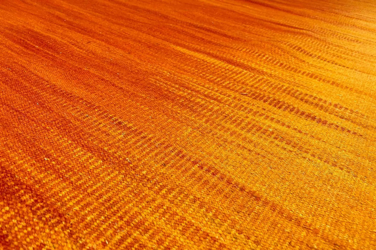 Yellow-orange kilim rug with a fine woven pattern, close-up of the surface
