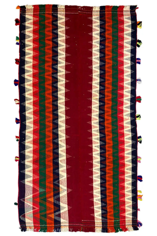 Rectangular jajim rug with vertical stripes in red, cream, green, and blue, tassels
