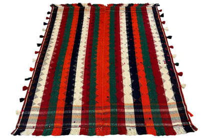 Jajim rug with a vertical striped pattern in red, green, blue, and cream, with tassels along the edge.