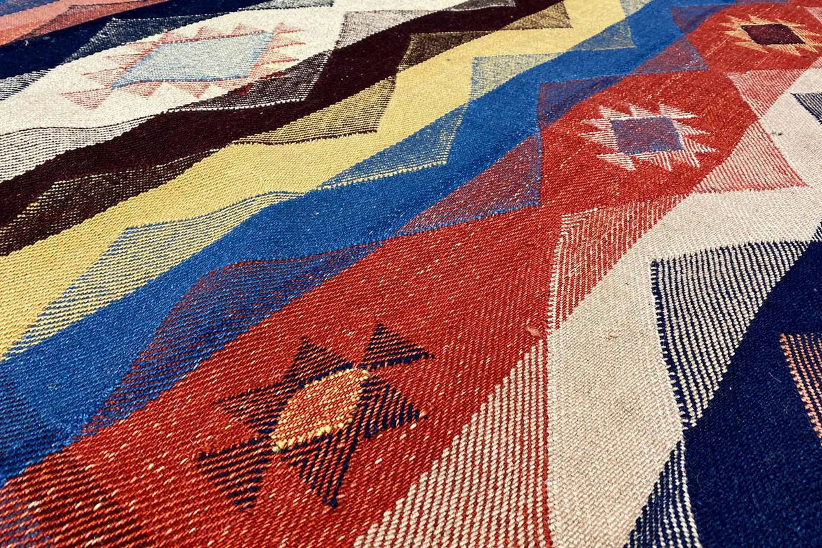 Jajim exclusive rug: close-up of geometric ornaments in red, blue, and yellow
