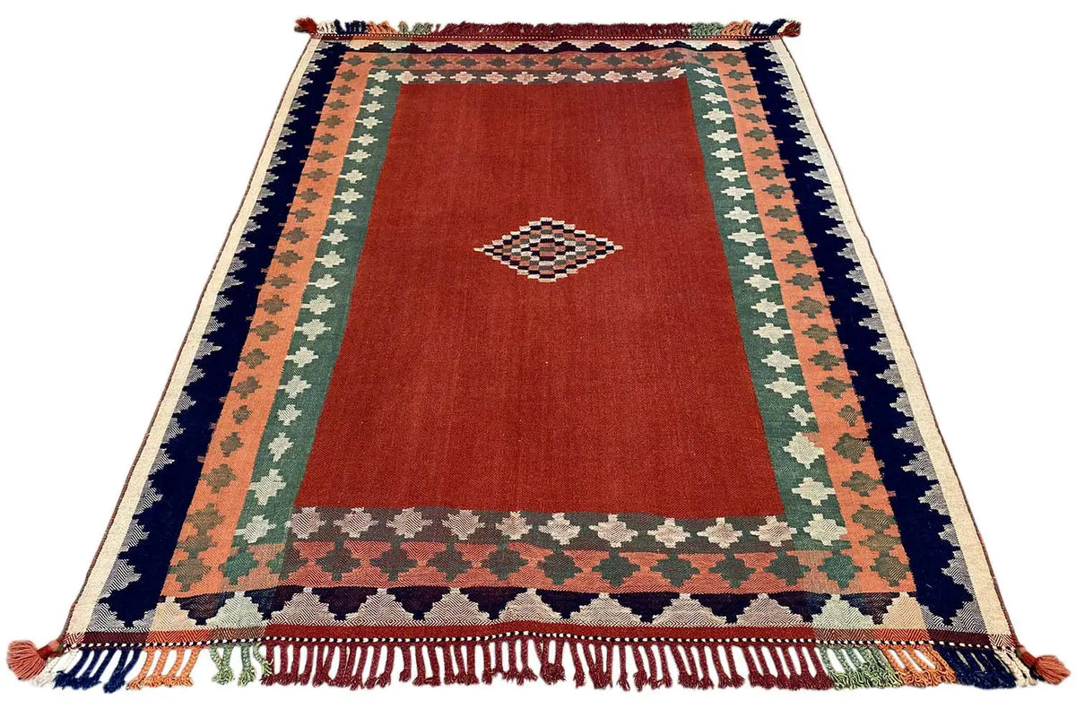 Jajim rug with a red center, green field, dark blue border, and fringes