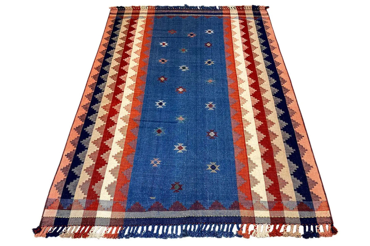 Rectangular rug with a blue center, a red-and-white zigzag stripe pattern, and fringes