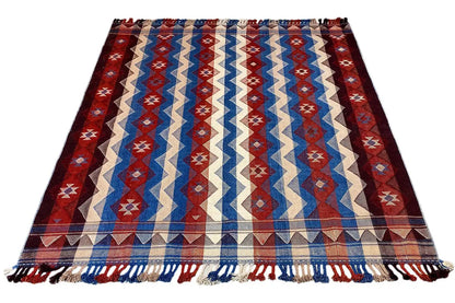 Jajim rug with a broad zigzag stripe pattern in red, blue, and cream, tassels