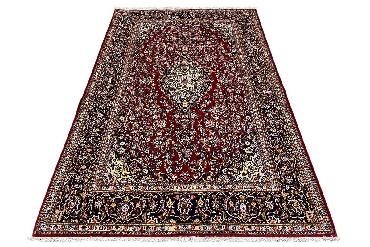 Keshan rug with a red patterned field, wide border and ornamental bands