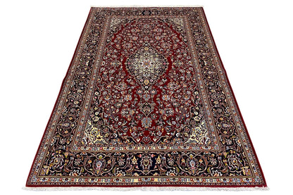 Keshan rug with a red patterned field, wide border and ornamental bands