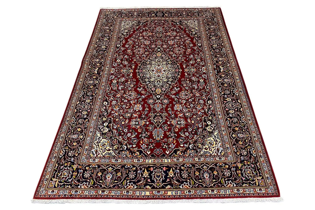 Keshan rug, burgundy field with a light medallion, surrounding ornamental border in dark blue.