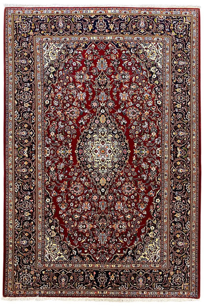 Keshan rug with a red field, central medallion, and wide dark patterned border.