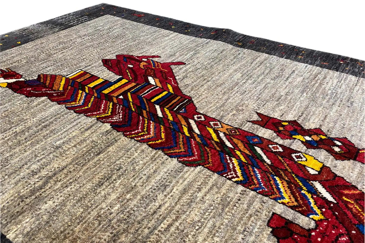 Gabbeh rug detail: colorful lion embroidery on a beige background, dark border edge