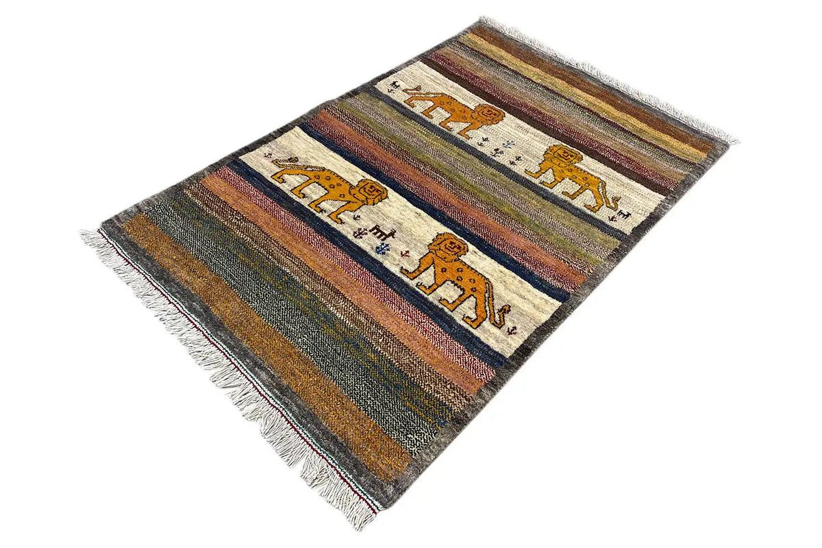 Gabbeh rug photographed at an angle, with stripes, lion motifs, and a fringed edge