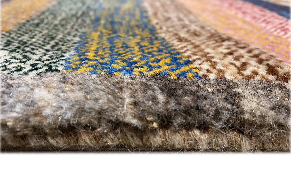 Close-up of the carpet surface: multicolored stripes, dense pile, and a frayed edge