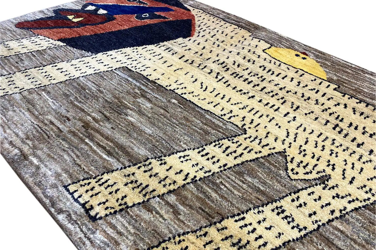 Close-up of Gabbeh rug: lion's head over a yellow dotted pattern on a gray-brown background