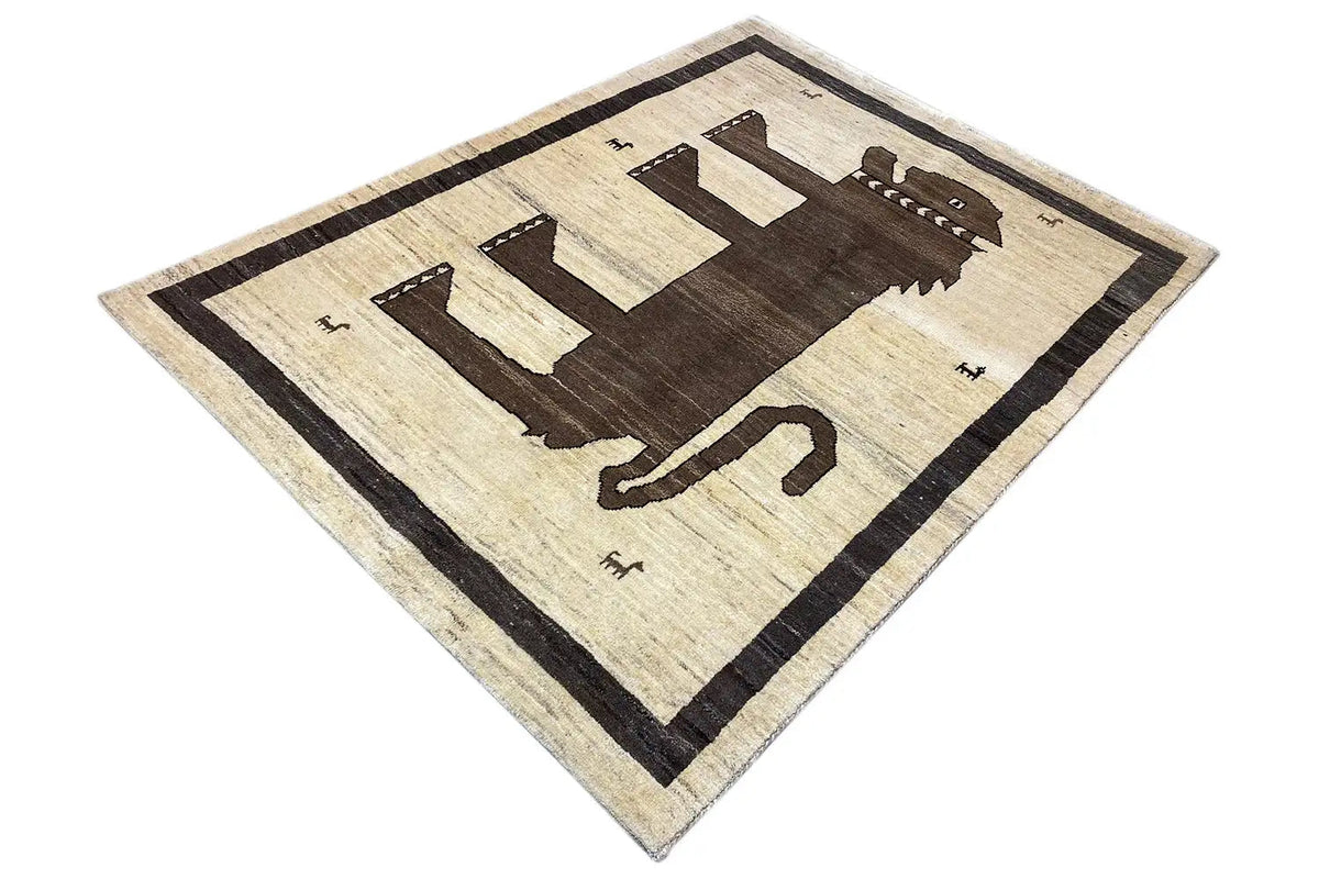 Gabbeh rug in a diamond layout, central animal/arrow motif, light beige with dark brown accents