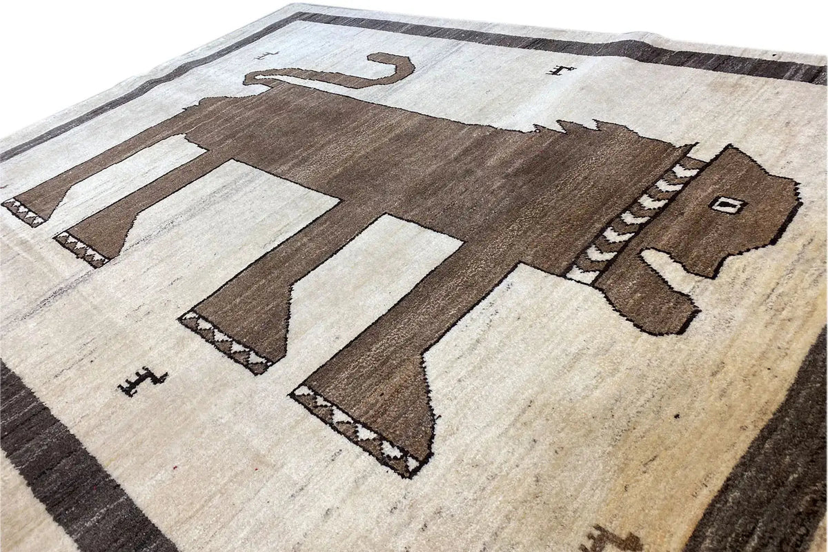 Gabbeh rug close-up: animal and arrow motifs, light beige areas, dark brown parts, black