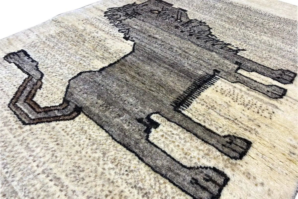 Close-up of Gabbeh rug: lion motif in dark gray on a light beige background