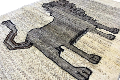 Close-up of Gabbeh rug: lion motif in dark gray on a light beige background
