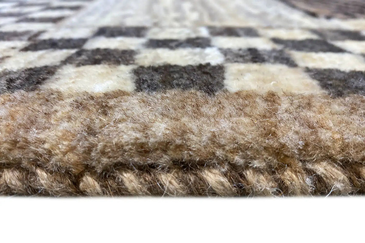 Carpet pile in detail: beige-brown fibers with dark stripes, short and dense