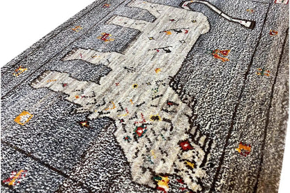 Close-up of Gabbeh rug: lion motif and colorful dots on a gray background