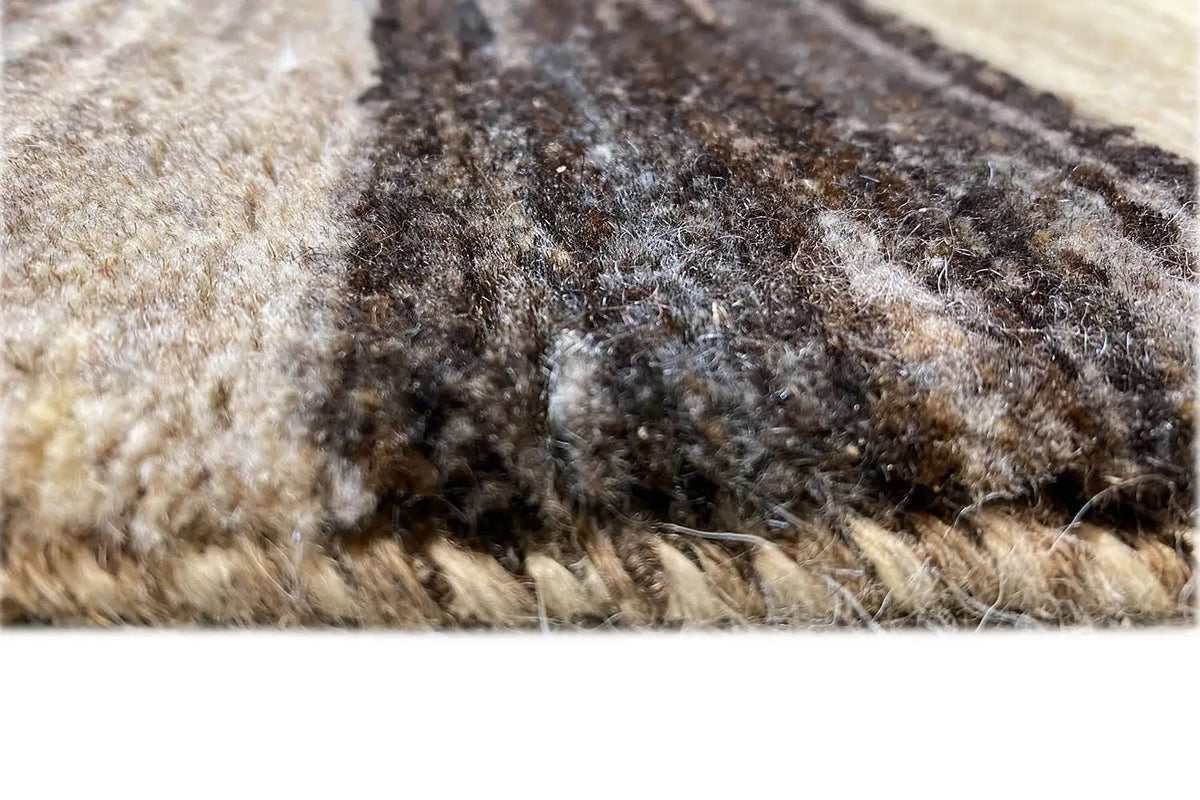 Carpet surface with dense pile and multicolored threads in beige and dark brown.