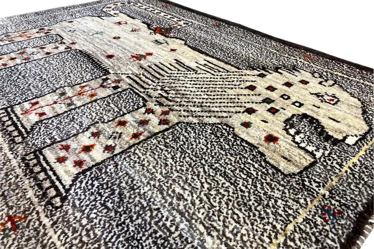 Close-up of a Gabbeh rug: gray textured pile, cream pattern, small red ornaments