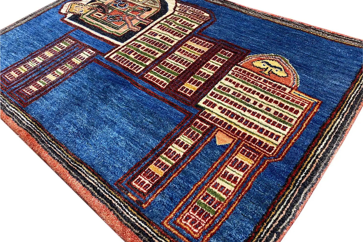 Blue Gabbeh rug, close-up diagonal view with a red and beige lion and city pattern