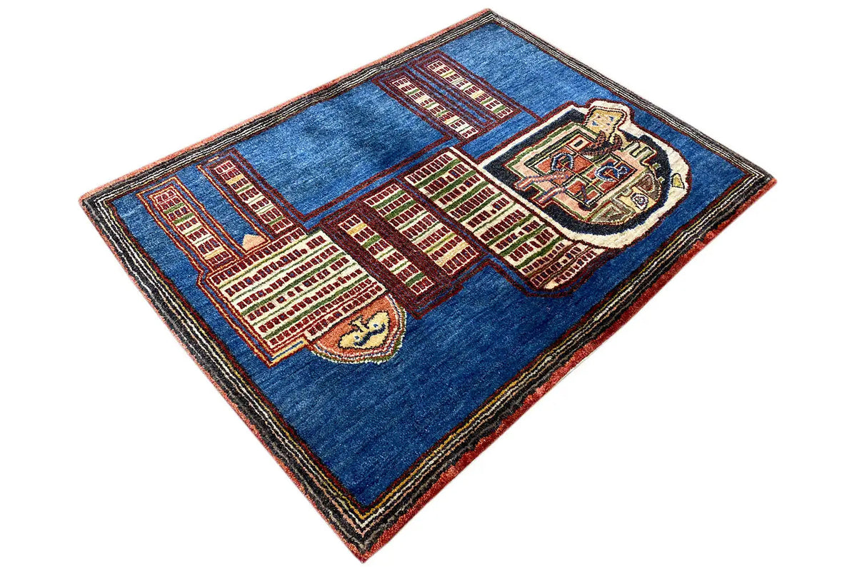 Blue Gabbeh rug spread out diagonally with red and beige lion and building motifs