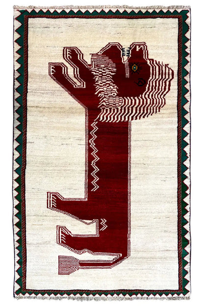 Gabbeh rug with a beige background, red motif, and green decorative border