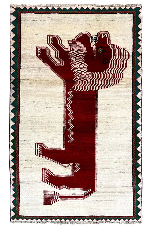 Gabbeh rug with a beige background, red motif, and green decorative border