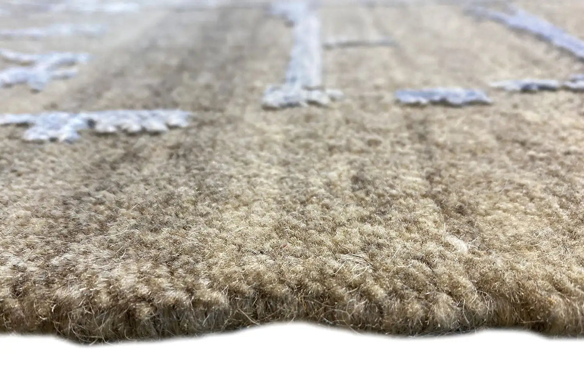 Gray-brown carpet pile with worn blue-and-white threads, close-up