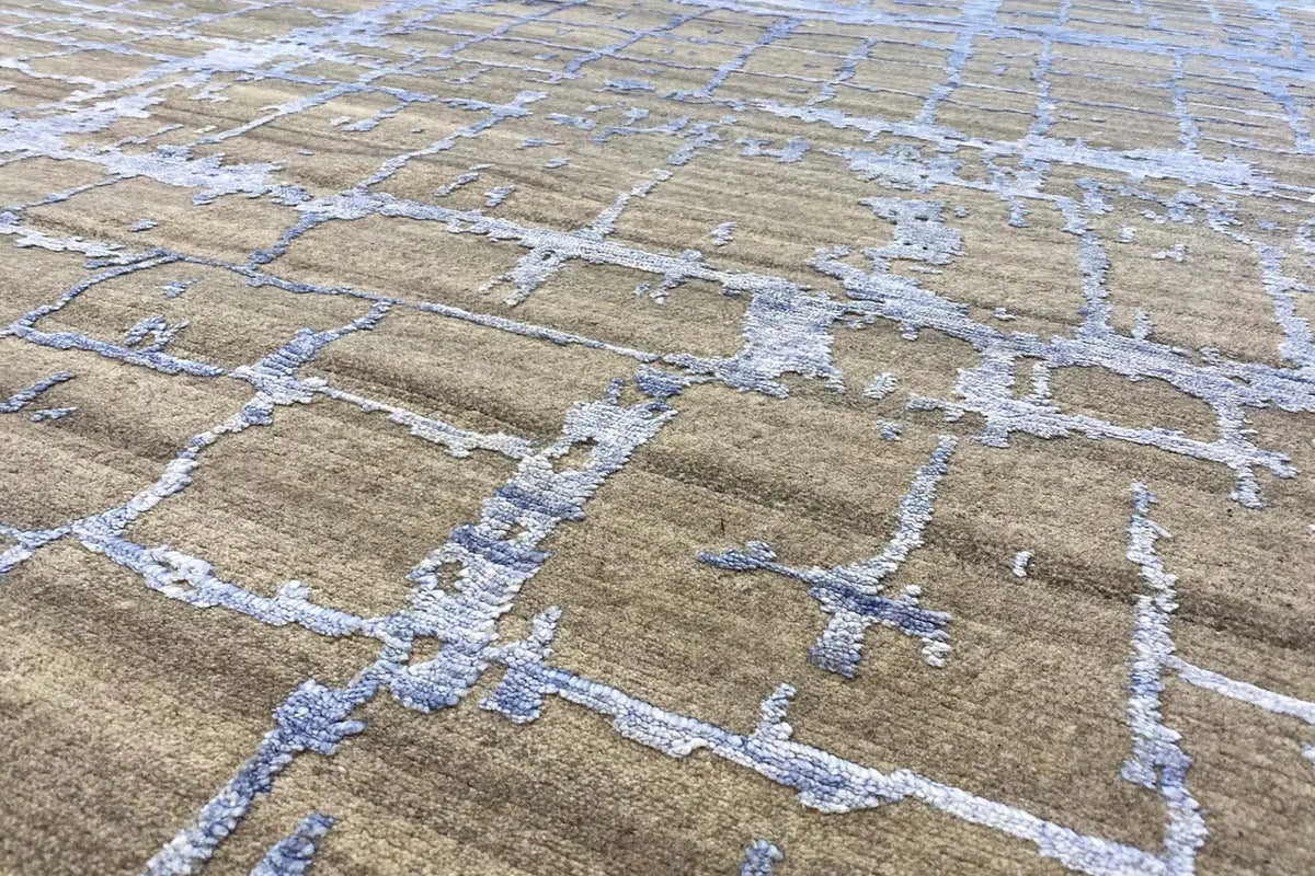 Rug with a taupe background, blue-and-white cross and line patterns, close-up