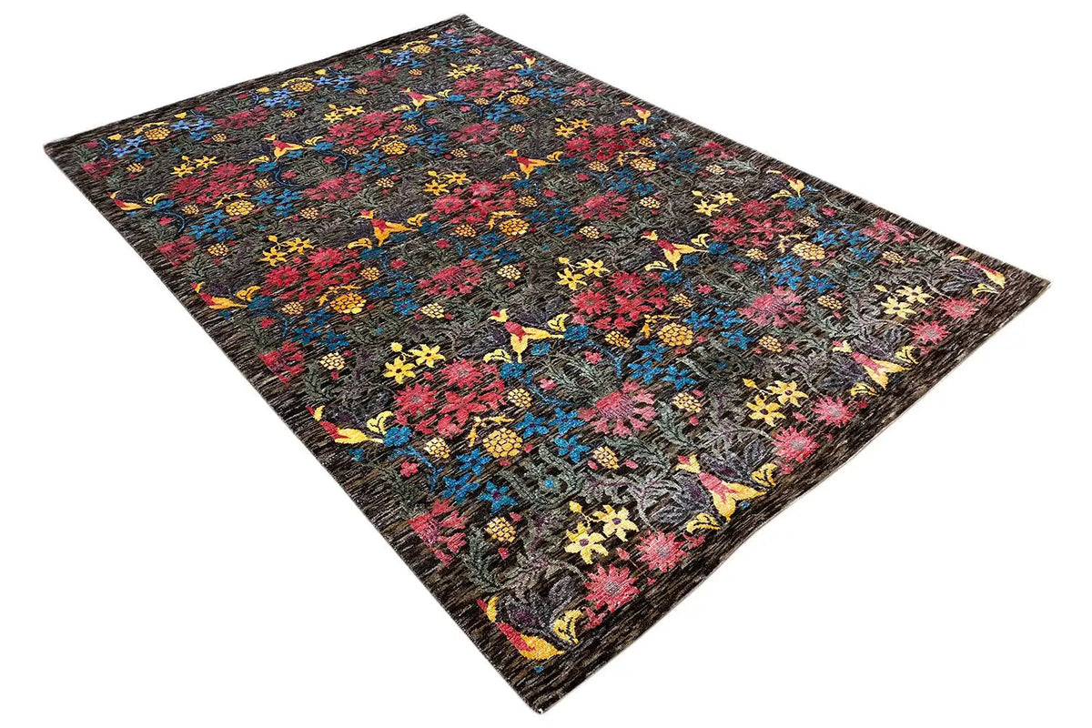 Rectangular rug with a colorful floral and ornamental pattern on a dark background