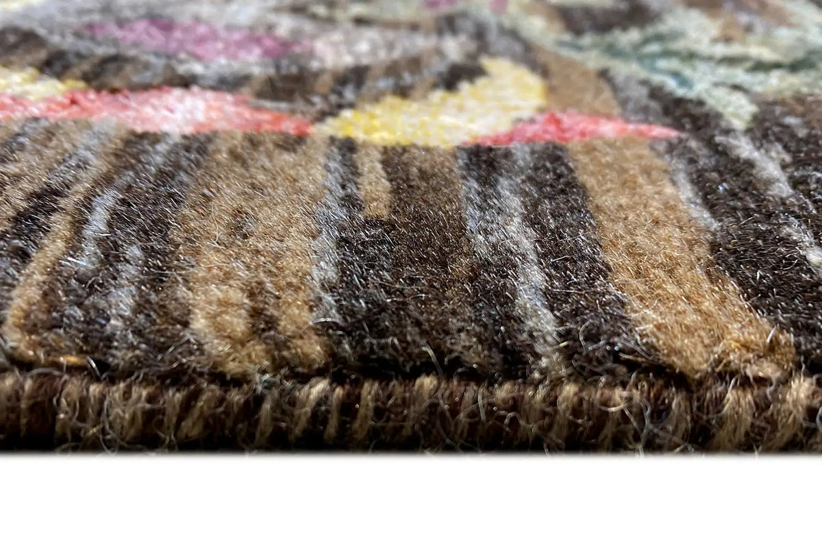 Carpet pile in detail: brown-beige and dark fibers with multicolored flecks