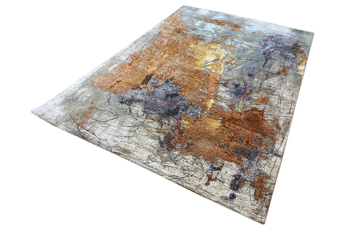 Designer rug laid out horizontally, abstract texture in brown, blue, and white-gray