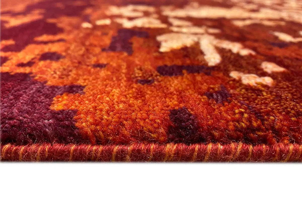 Reddish-brown carpet pile with multicolored effect areas along the edge