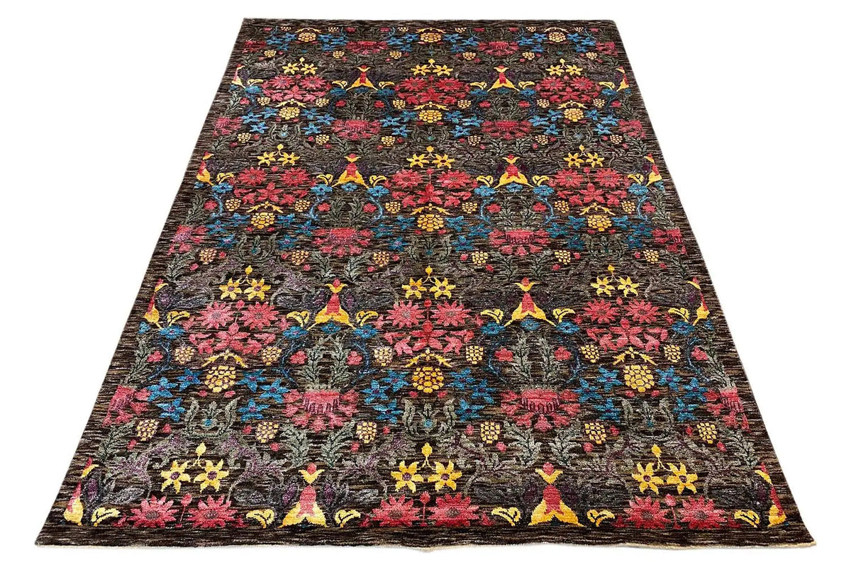 Rectangular designer rug with a dense, colorful pattern on a dark background