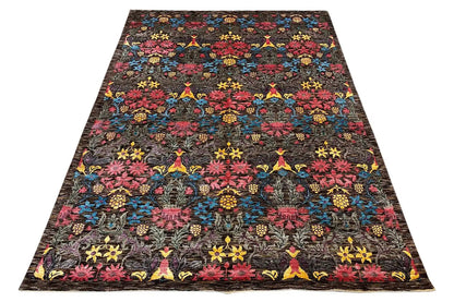 Rectangular designer rug with a dense, colorful pattern on a dark background
