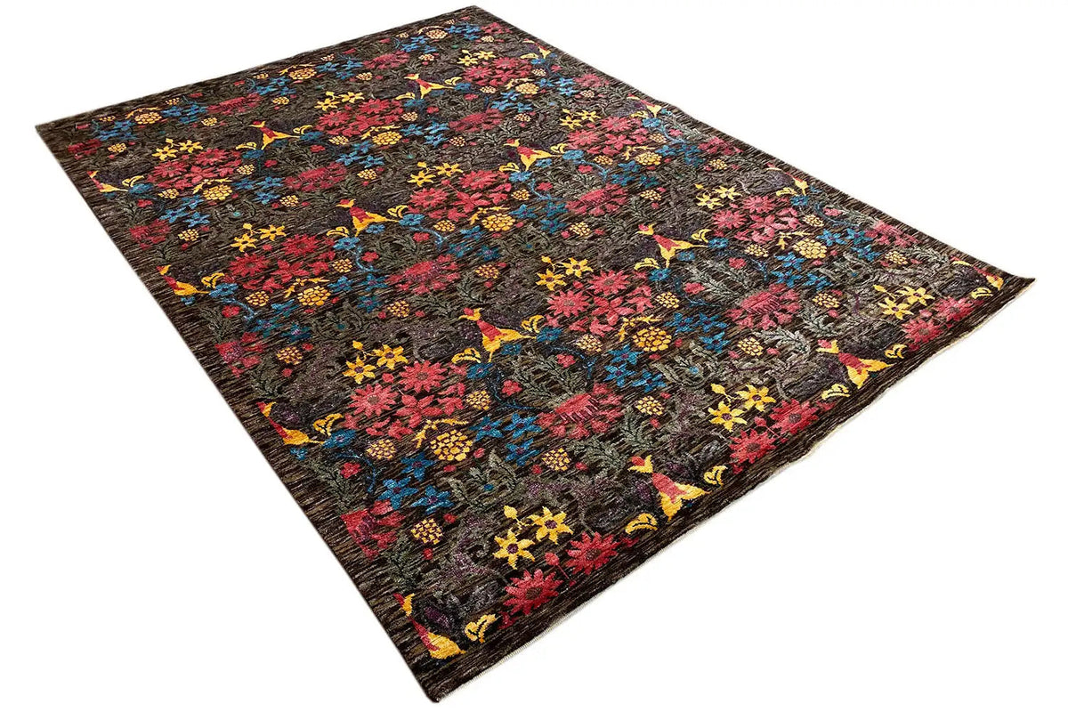 Designer rug viewed diagonally: dark pattern with pink, yellow and blue accents