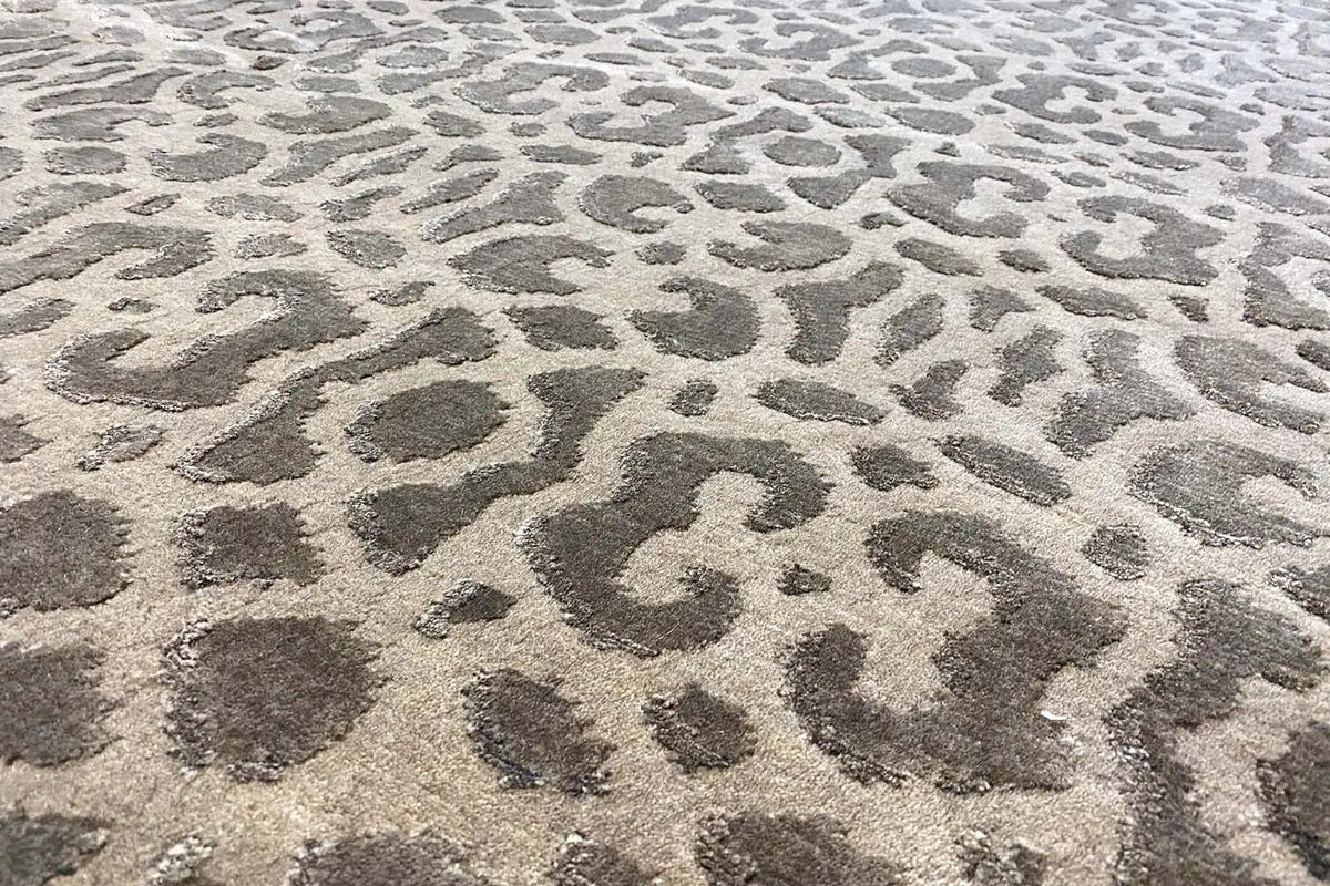 Carpet surface with a dense animal pattern in dark gray on a light background