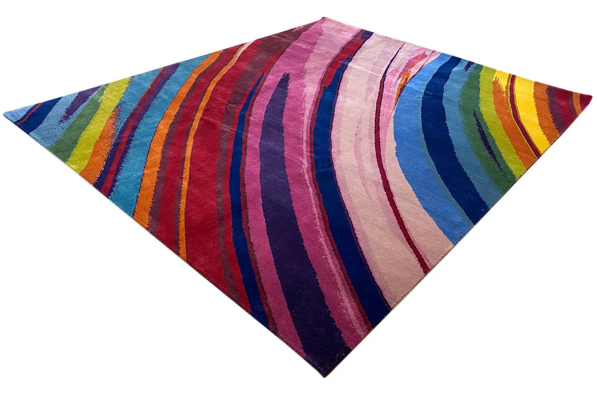Colorful striped rug with a curved color arc in pink, blue, and yellow