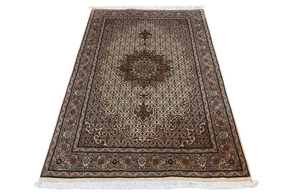Rectangular rug with decorative border, beige background and dark medallion, fringe