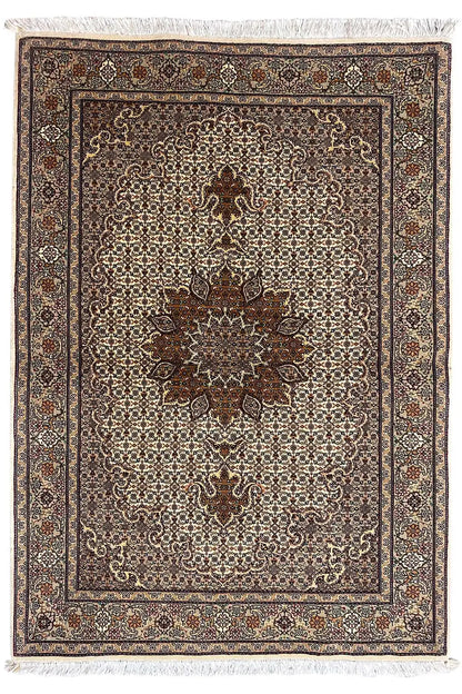 Rug with a central floral pattern, brown border, and beige background, with fringes