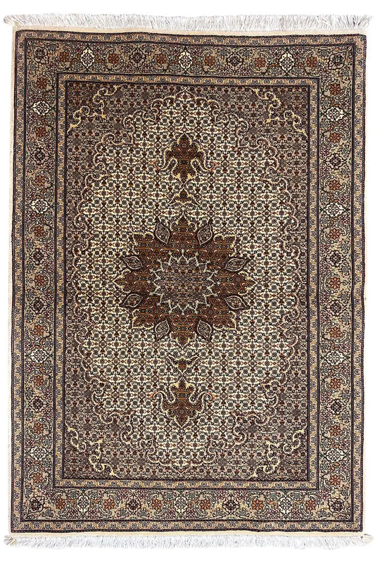 Rug with a central floral pattern, brown border, and beige background, with fringes