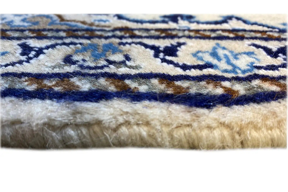 Close-up: Rug edge with fringes on the blue-and-white Nain pattern