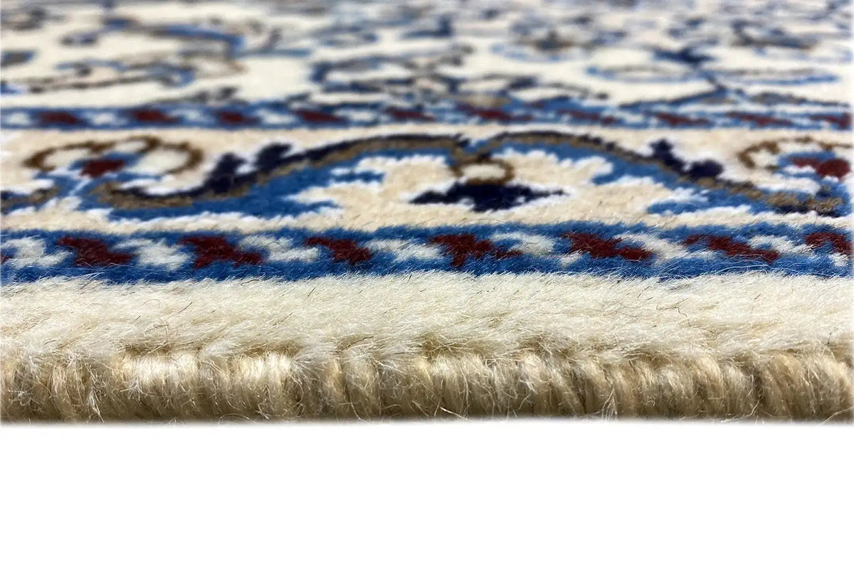 Rug detail: fringe trim at the bottom, blue-and-white ornamental pattern, dense pile