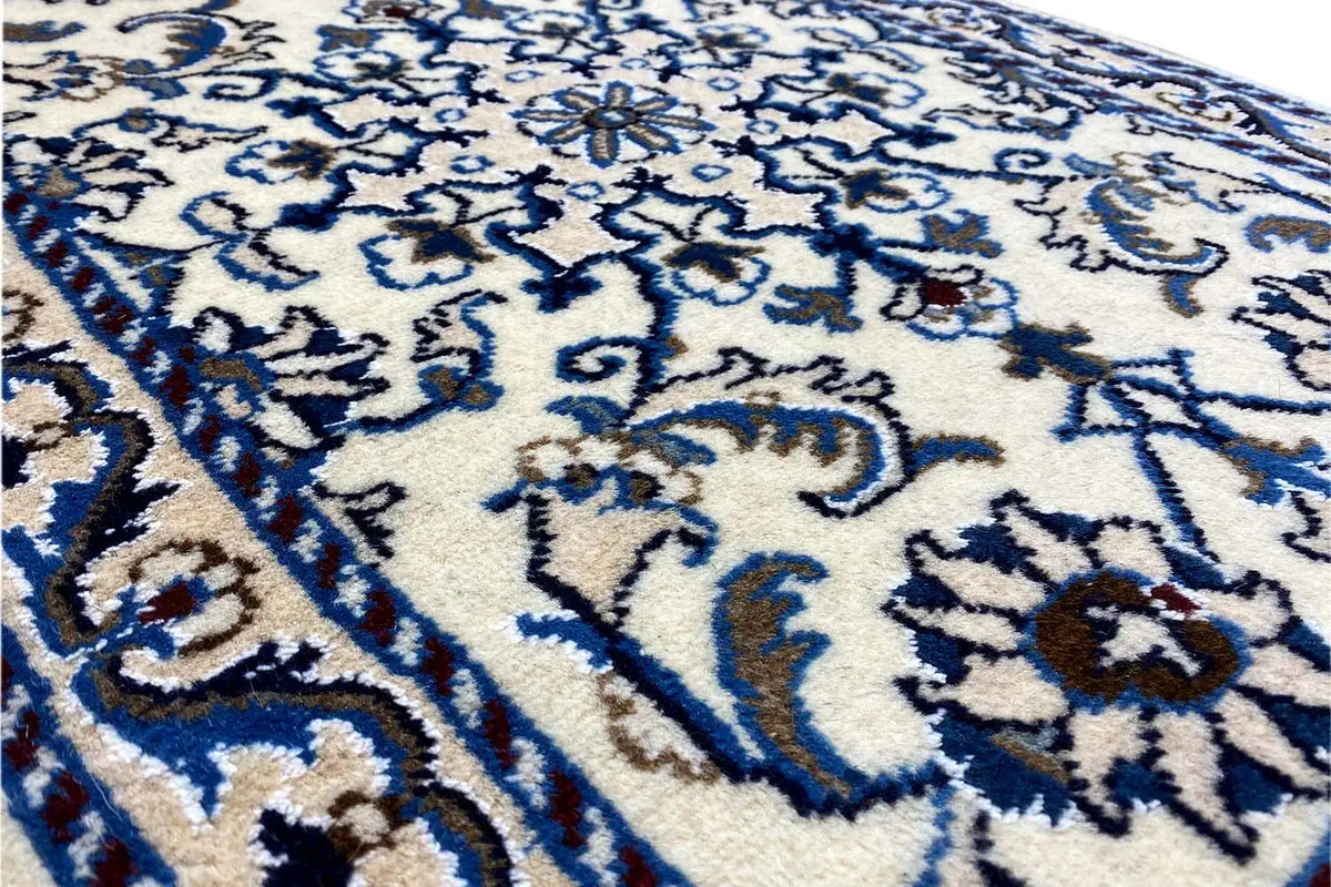 Close-up: blue-and-white ornamental pattern on a light background, finely woven pile