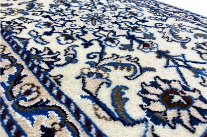 Close-up: blue-and-white ornamental pattern on a light background, finely woven pile